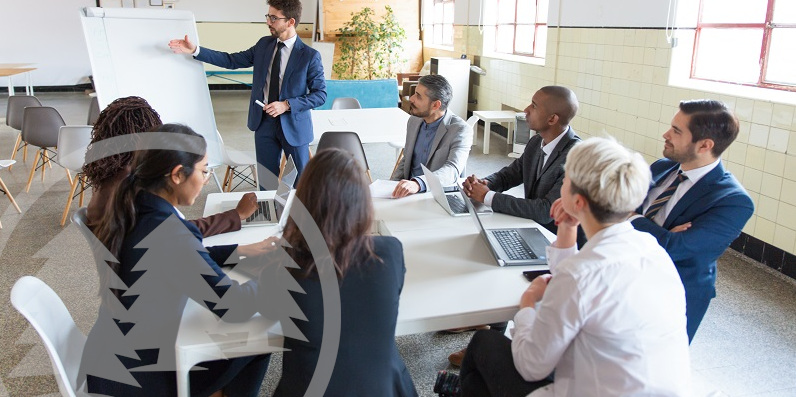 Group of people sitting at table and listening to speaker | hiring an association management company