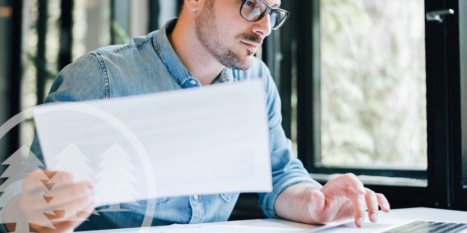 man using laptop while holding paper on other hand man using laptop while holding paper on other hand | hoa accountant