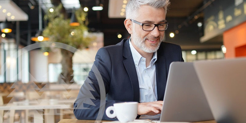man in suit smiling in front laptop | benefits of hiring an hoa management company