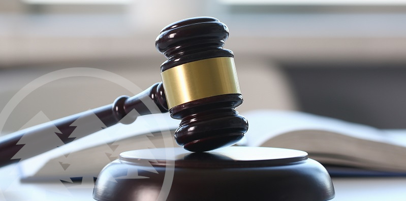 gavel lies on table with law book in the background | how can enforce hoa rules