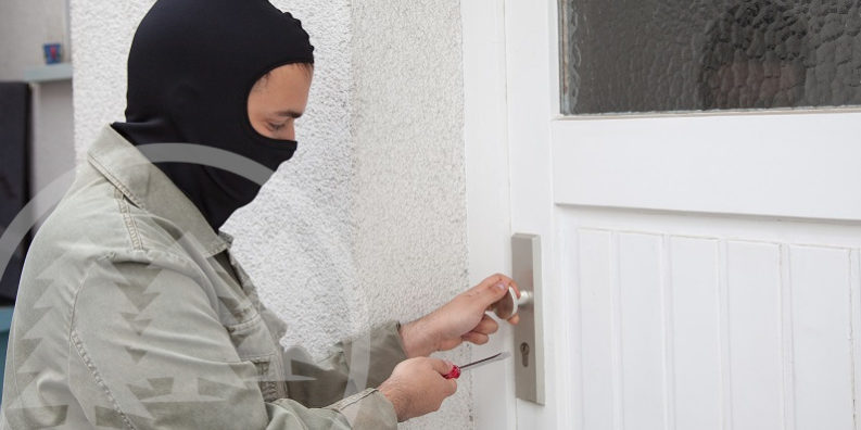 burglar unlocking door | crime prevention in an HOA