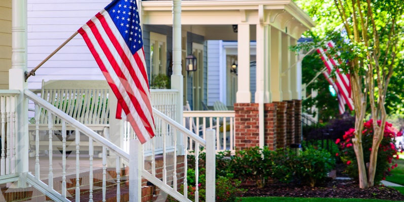 A line of suburban homes display large American Flags | hoa flag rules