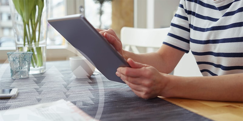 woman using a tablet | write hoa newsletters